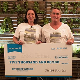 Smiling couple holding poster-sized check